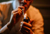 A man lighting a cigar with a flip lighter.